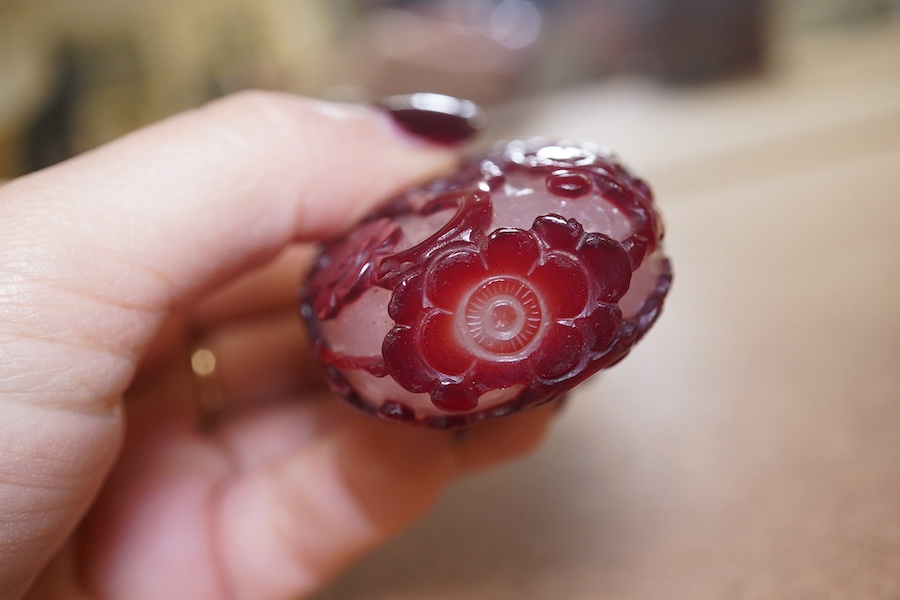 A Chinese cameo carved red overlaid on white snowflake ground snuff bottle and stopper, 19th century, 8cm high. Condition - small splinter chip to base, otherwise good